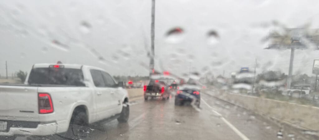 View from inside car on Houston freeway in heavy rain — daily commute reality in Katy and Houston TX