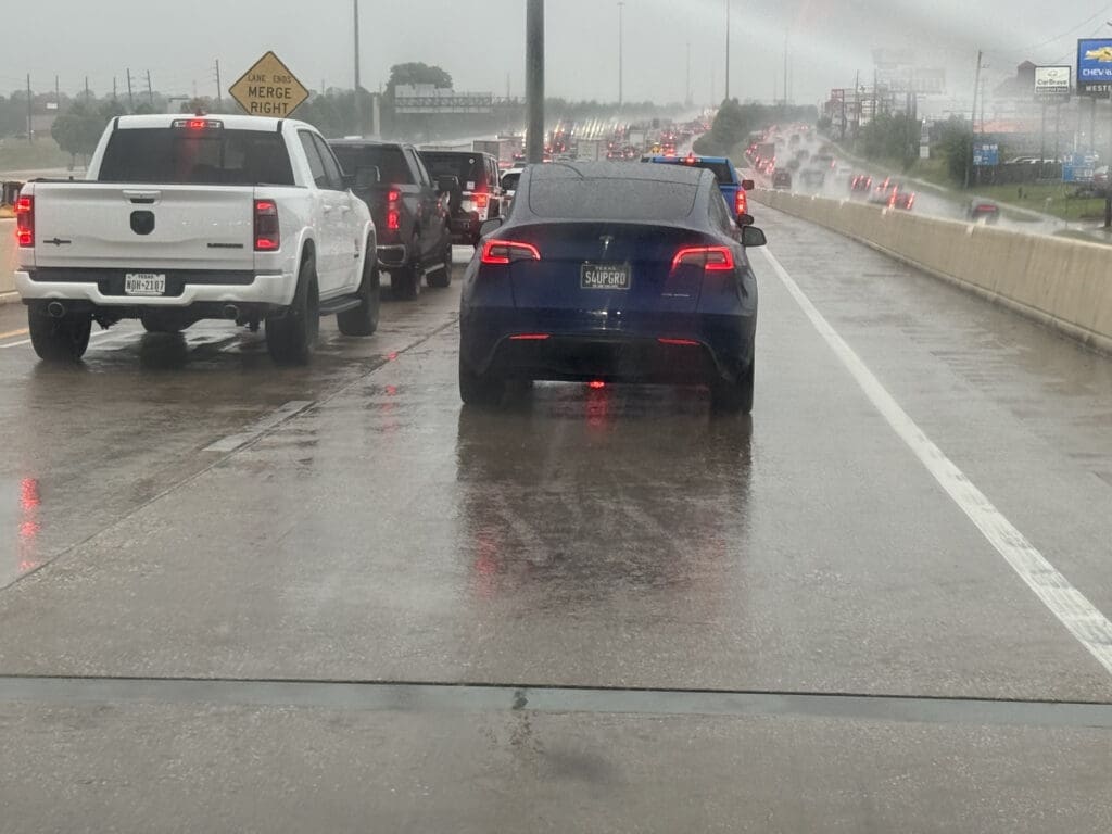 View from inside car on Houston freeway in heavy rain — daily commute reality in Katy and Houston TX