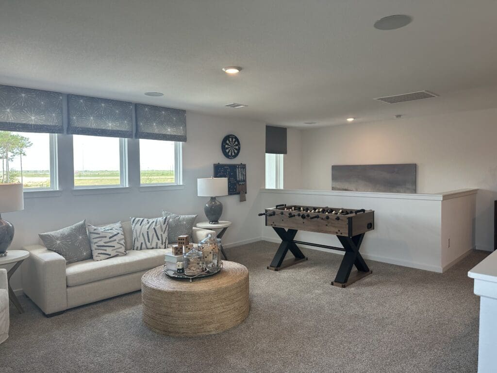 Upstairs game room loft with foosball table in a Katy Texas new construction home — basement alternative living space
